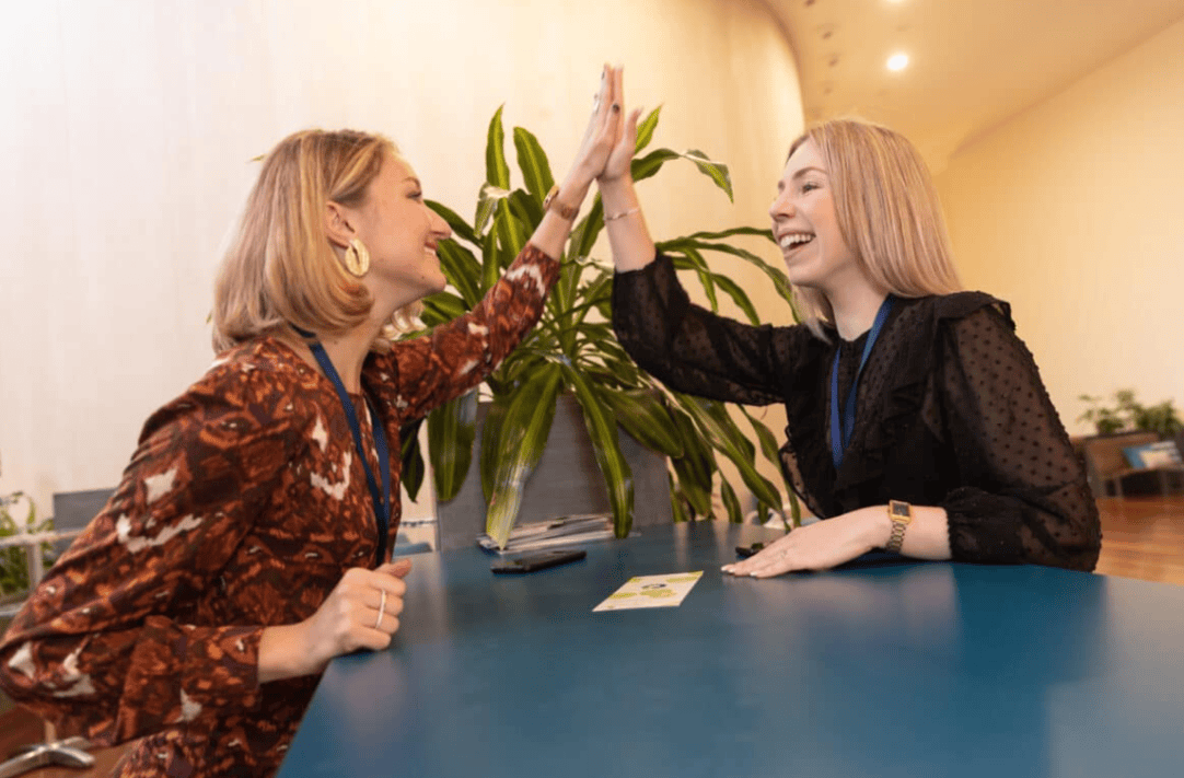 Two female Ipsen employees doing a high five move celebrating